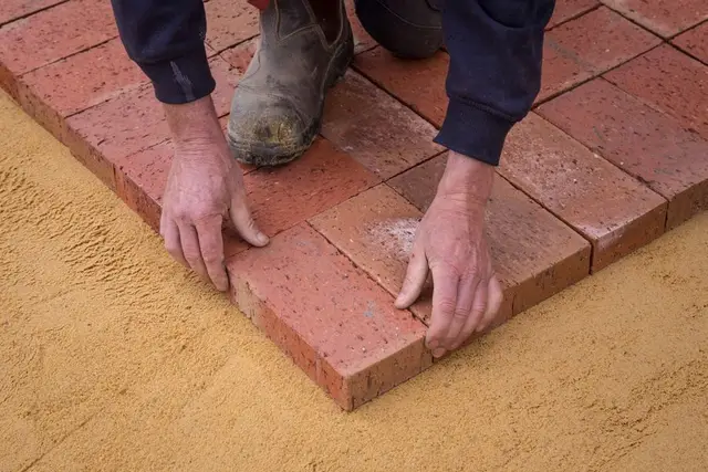 Pavers being laid on a sand and gravel base